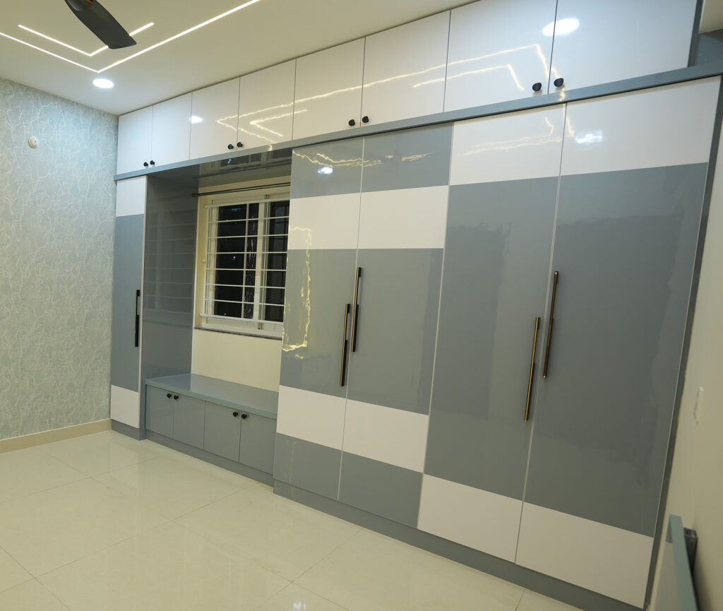 Glossy grey and white wardrobe design for a residential bedroom in Hyderabad
