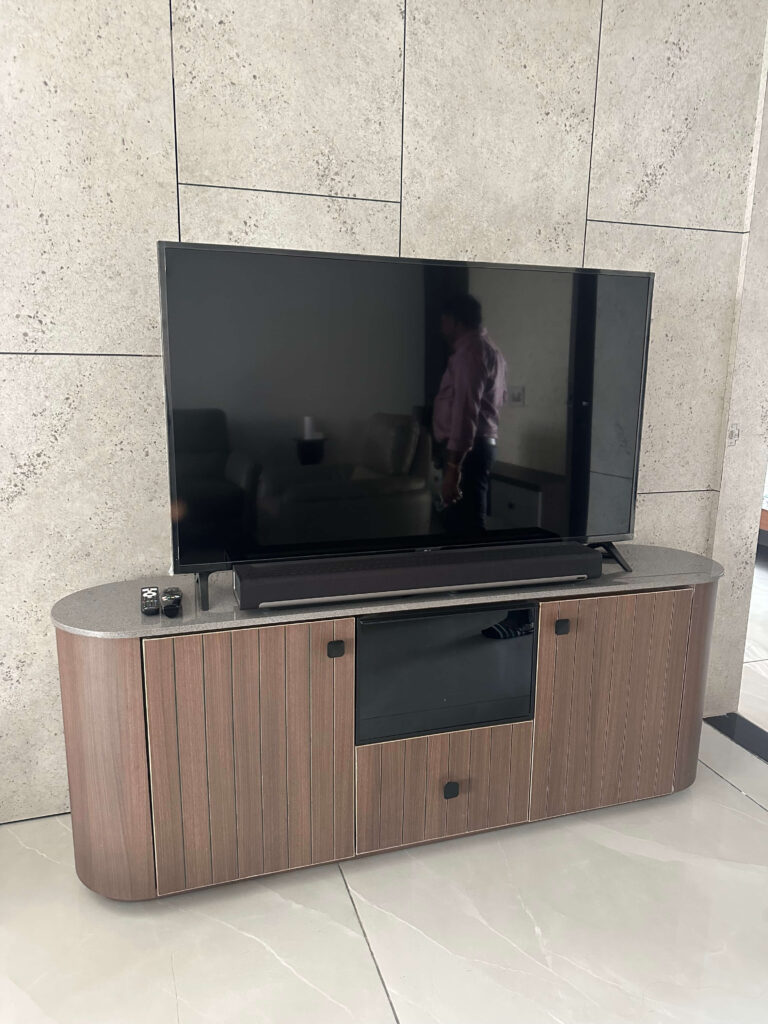 Villa TV unit with stone-finish wall and wood console by IWY Designs