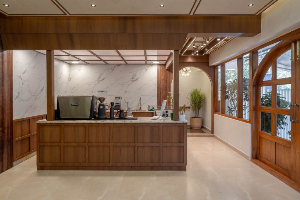 OneTen cafe coffee counter with wood paneling and warm lighting by IWY Designs Hyderabad