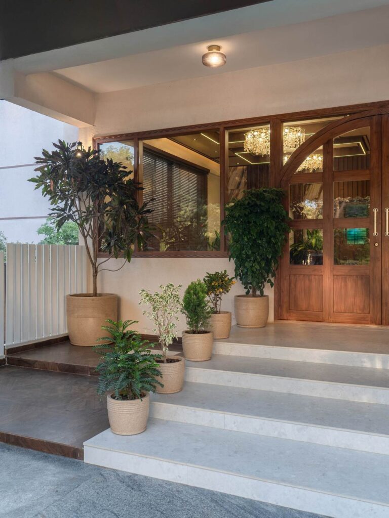 OneTen cafe entry steps with greenery and warm exterior lighting by IWY Designs Hyderabad