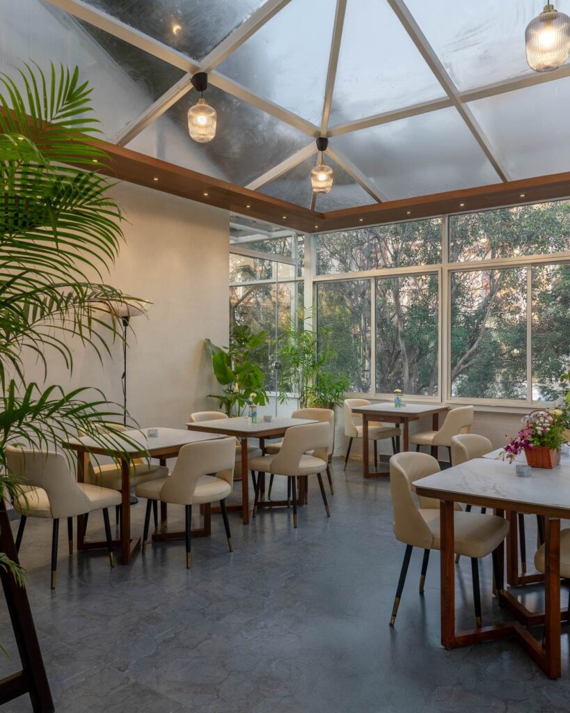 OneTen cafe gazebo dining ambience with warm lights plants and open seating by IWY Designs Hyderabad