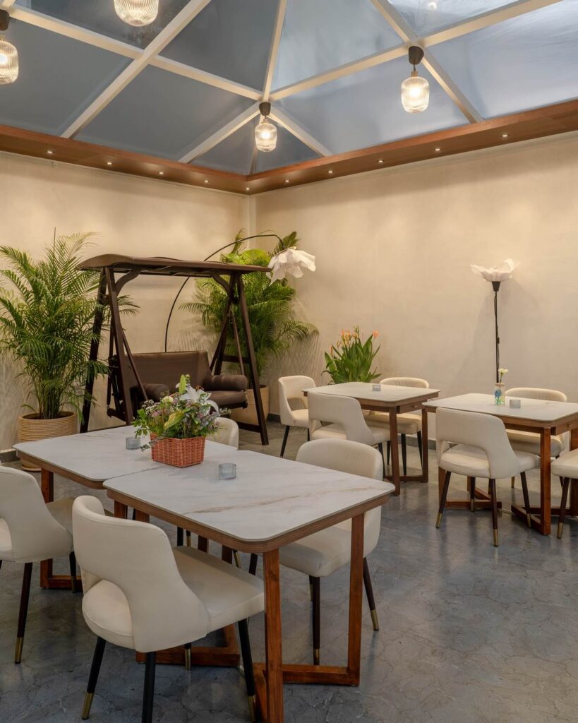 OneTen cafe gazebo dining area with glass roof and indoor outdoor seating by IWY Designs Hyderabad