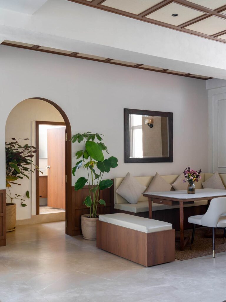 OneTen cafe private dining nook with arched mirror and soft neutral finishes by IWY Designs Hyderabad