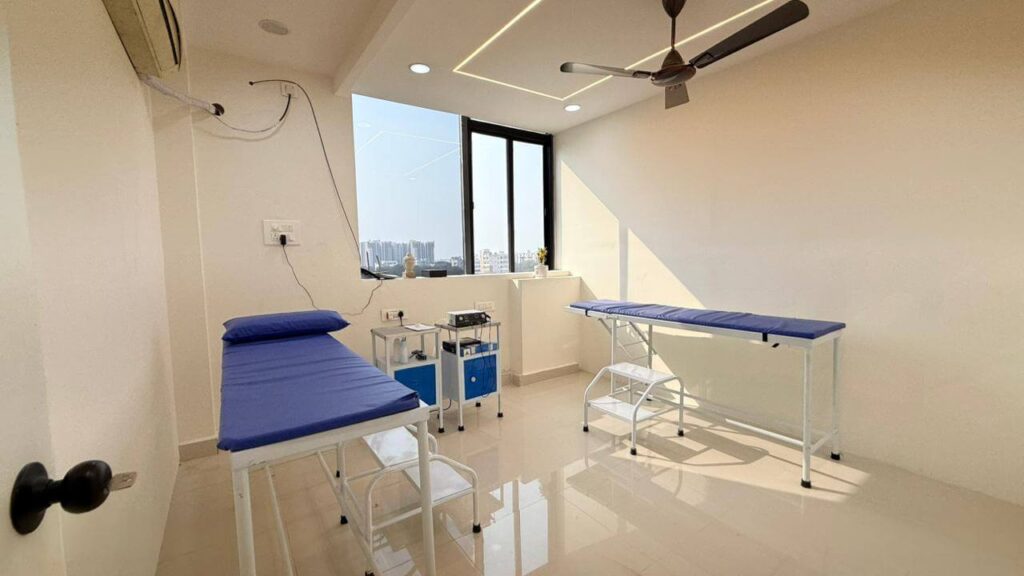 Clinic treatment room with blue examination beds and clean functional layout designed by IWY Designs in Hyderabad