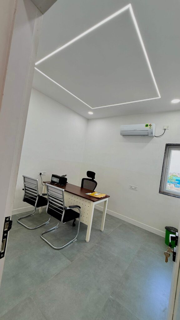 Diagnostics consult room with desk and geometric ceiling lighting by IWY Designs
